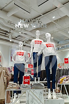 Shop window with mannequins in T-shirts with the inscription Sale.