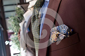 Shop window of mens tailor shop showing brightly coloured suit material and fabrics su