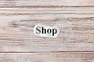 SHOP of the word on paper. concept. Words of SHOP on a wooden background