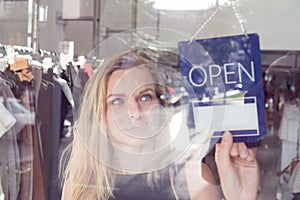 Shop worker with the open and closed sign