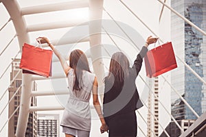 Shopaholic lifestyle friendship women holding shopping bag in shopping mall center. Black Friday and cyber Monday sale concept.