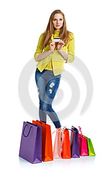 Shopaholic woman with shopping bags and credit card over white b