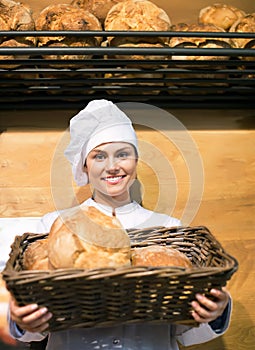 Shopgirl working in bakery with bread and different pastry