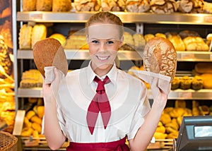 Shopkeeper holding two different loafs of bread