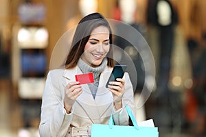 Shopper holding shopping bags paying on line