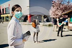 Shopper with mask standing in line  to buy groceries due to coronavirus pandemic in grocery store.COVID-19 shopping safety