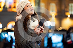 Shopper woman buying online on the smart phone at Christmas. People shopping communication concept