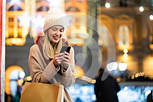 Shopper woman buying online on the smart phone at Christmas. People shopping communication concept