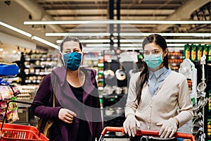 Shoppers with masks buying for groceries due to coronavirus pandemic in grocery store.COVID-19 food shopping.Quarantine