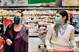 Shoppers with masks buying for groceries due to coronavirus pandemic in grocery store.COVID-19 food shopping.Quarantine