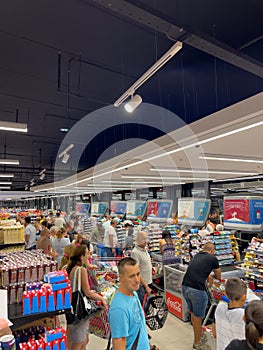 Budva, Montenegro - 01 august 2023: Shoppers with shopping carts stand at the checkout counters of the supermarket