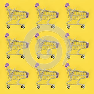 Shopping addiction, shopping lover or shopaholic concept. Many small empty shopping carts perform a pattern on a pastel colored