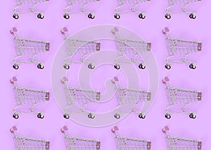 Shopping addiction, shopping lover or shopaholic concept. Many small empty shopping carts perform a pattern on a pastel colored