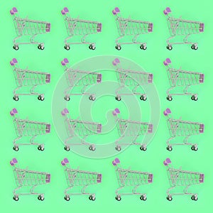 Shopping addiction, shopping lover or shopaholic concept. Many small empty shopping carts perform a pattern on a pastel colored