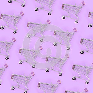 Shopping addiction, shopping lover or shopaholic concept. Many small empty shopping carts perform a pattern on a pastel colored