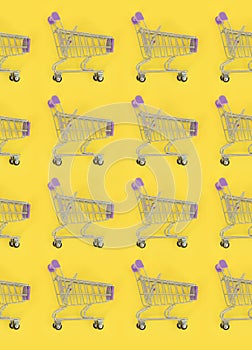 Shopping addiction, shopping lover or shopaholic concept. Many small empty shopping carts perform a pattern on a pastel colored