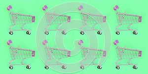 Shopping addiction, shopping lover or shopaholic concept. Many small empty shopping carts perform a pattern on a pastel colored