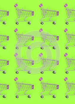 Shopping addiction, shopping lover or shopaholic concept. Many small empty shopping carts perform a pattern on a pastel colored