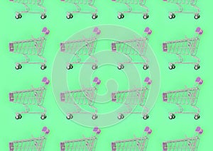 Shopping addiction, shopping lover or shopaholic concept. Many small empty shopping carts perform a pattern on a pastel colored