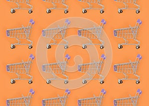 Shopping addiction, shopping lover or shopaholic concept. Many small empty shopping carts perform a pattern on a pastel colored