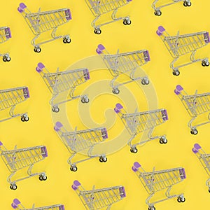 Shopping addiction, shopping lover or shopaholic concept. Many small empty shopping carts perform a pattern on a pastel colored