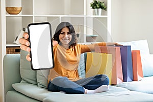 Shopping App. Cheerful Young Arab Woman Demonstrating Blank Smartphone At Camera