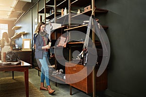 Shopping around for the latest sales. a young woman shopping in a leatherwork store.