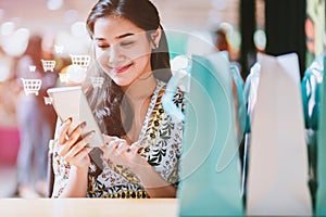 Shopping asian woman using mobile phone for online market shop in mall