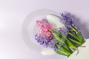 shopping bag with flowers and Easter bunny ears on a light background, top view. flatlay