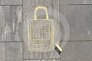 Shopping bag picture written on gray sidewalk in crayons