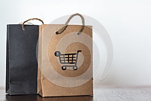 Shopping bags with cart icon on wooden table. Commercial business, retail sale, online shopping concept