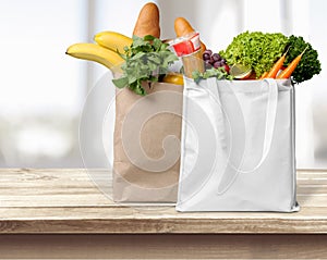 Shopping bags with groceries on white photo