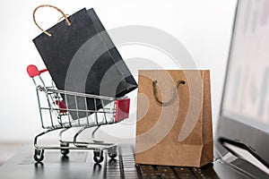 Shopping bags and trolley on computer keyboard. Online shopping, e-commerce concept