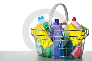 Shopping basket with different detergents on grey table