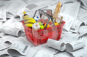 Shopping basket with foods on the pile of receipt.   Consumerism and grocery expenses budget