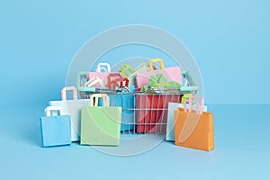 Shopping basket full of paper bags. Sesonal sale, online deals, discounts, promotions idea