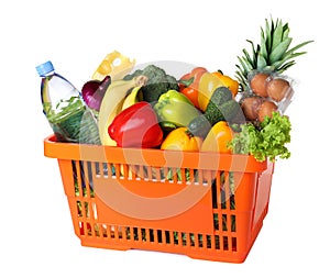 Shopping basket with grocery products on background