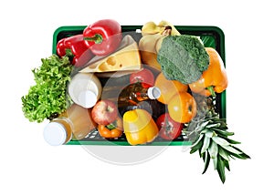 Shopping basket with grocery products on background, top view