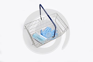 Shopping basket with hand gloves and mouth mask, isolated on white background