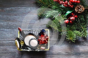 Shopping basket with makeup cosmetic product and fir branches on wooden background. Shopping, new year sale. Advertising