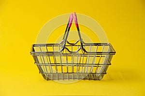 Shopping basket on a yellow background. Supermarket food price concept