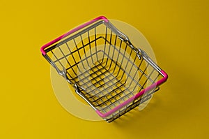 Shopping basket on a yellow background. Supermarket food price concept