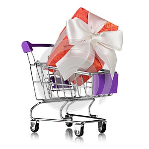 Shopping cart with big pink gift with bow isolated on white