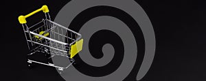 Shopping cart on a black background with blank space for inserting text. Business concept.