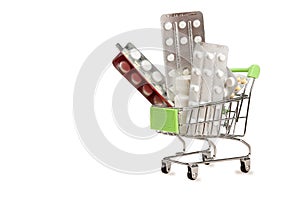 Shopping cart with blisters of tablets and pills concept of self-treatment and purchase of medicines