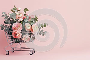 Shopping cart with blooming ranunculus and eucalyptus branches. Spring shopping, sale, discounts. Florist advertisement, copy