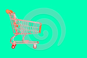 Shopping cart on a bright background with copy space. Minimal style. Discounts, sale of goods. The concept of shopping
