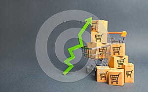 Shopping cart with cardboard boxes with a pattern of trading carts and a green up arrow. Increase the pace of sales, production