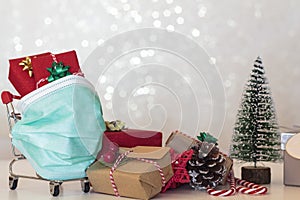 Shopping cart with Christmas gifts, christmas decoration and protective face mask
