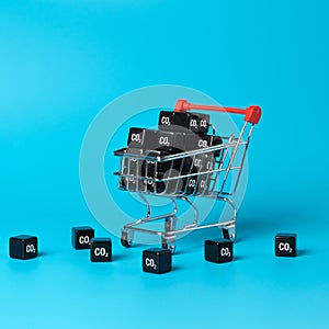 Shopping cart and CO2 carbon cubes. Greenhouse gas consumption and footprint.